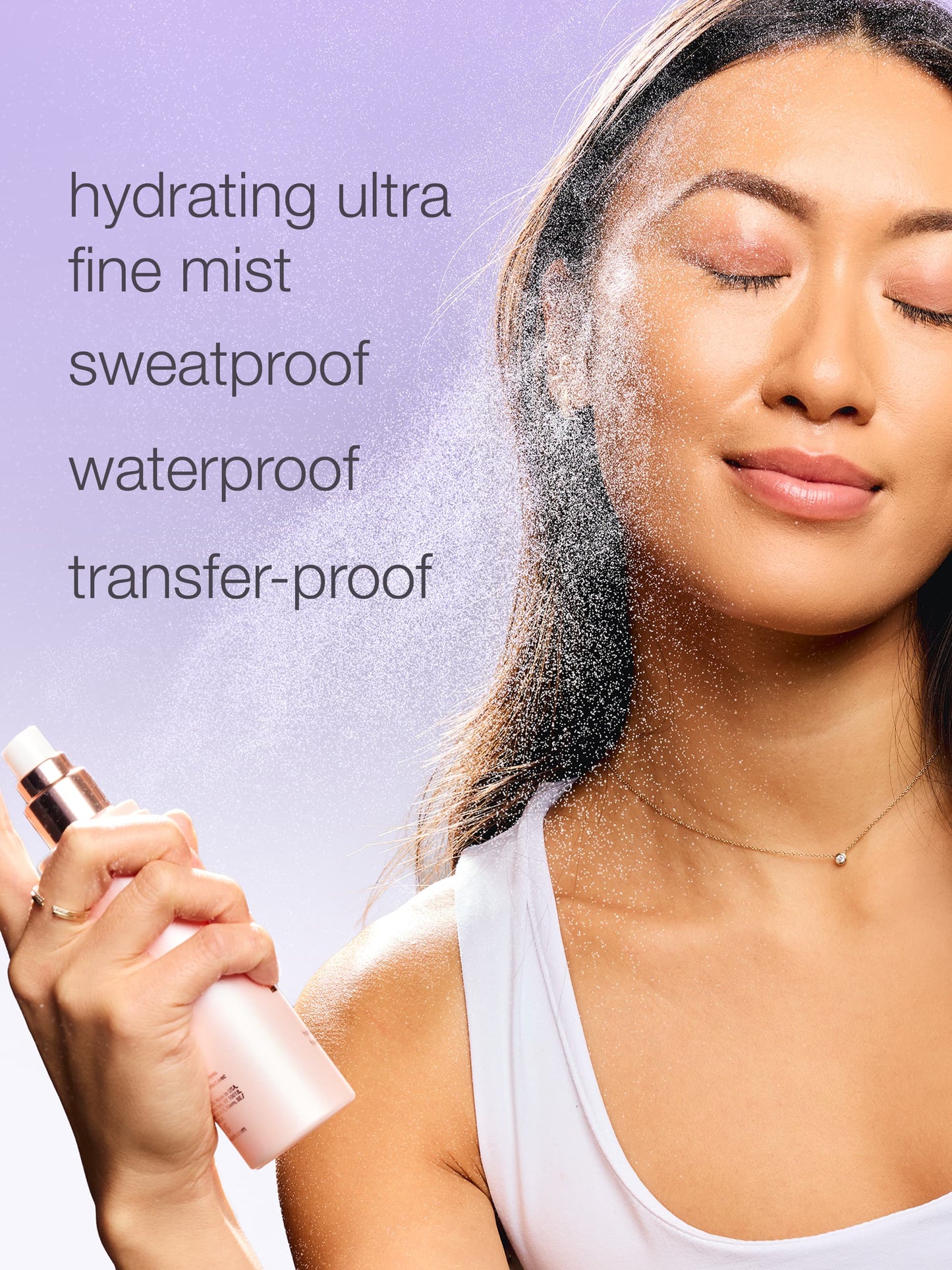 A woman sprays her face with a fine mist from a bottle against a purple background. Text reads: hydrating ultra fine mist, sweatproof, waterproof, transfer-proof.