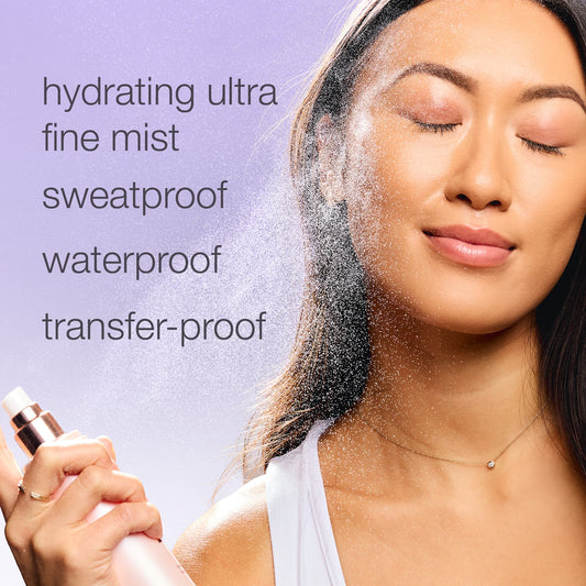 Woman sprays face with mist, eyes closed, in bright setting; labeled hydrating ultra fine mist, sweatproof, waterproof, transfer-proof.