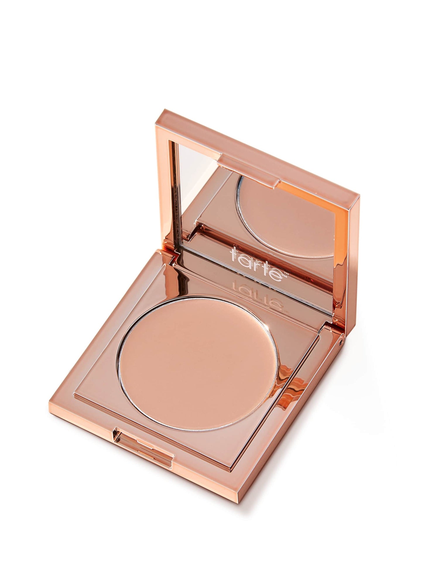 Rose-gold Tarte compact sits open, revealing a round pressed-powder pan and mirrored lid reflecting the tarte logo, set on a plain white background. Text in image: tarte