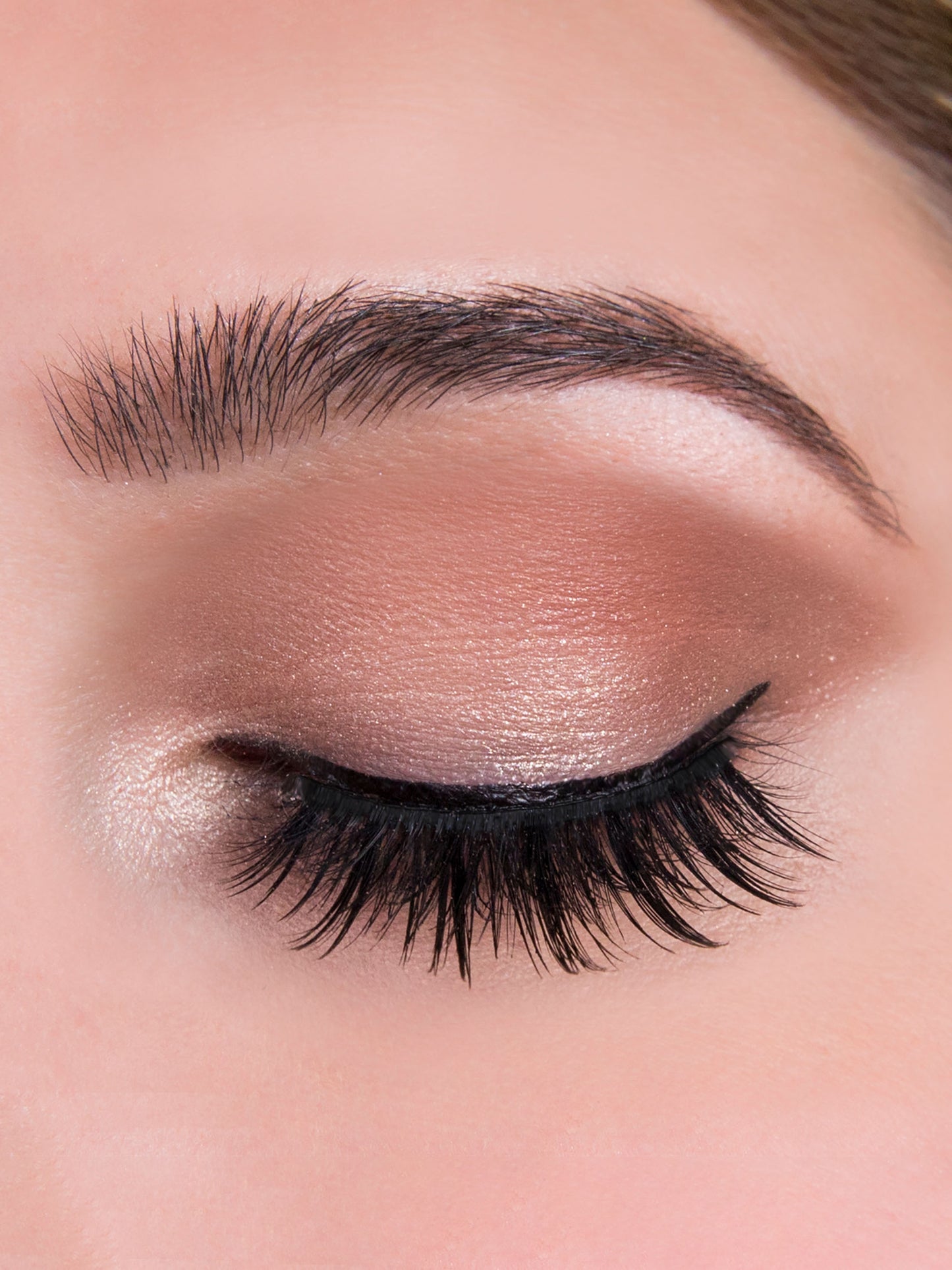 Close-up of a person's eye with smoky eyeshadow and long lashes.